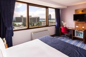 una camera d'albergo con letto, scrivania e finestra di Taxim Express Bosphorus Hotel a Istanbul