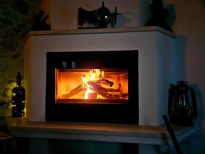 a fireplace with a fire in it in a room at Rafeio Roustic Maisonette in episkopi-heraklion