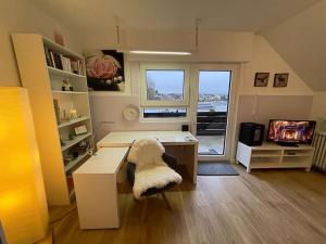 a small living room with a desk and a tv at Stilvolles Studio in Vallendar
