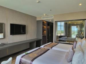 a hotel room with a bed and a large window at Diamond Stars Ben Tre Hotel in Ben Tre