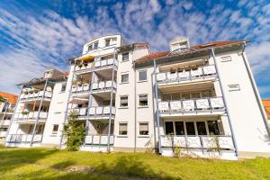 a white building with balconies and a blue sky at Grafschafft angenehmes wohnen - Ferienwohnung mit 2 Schlafzimmern in Pirna