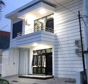 Casa blanca con balcón en la parte superior. en Mess Inn Semarang en Semarang