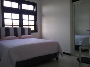 Postel nebo postele na pokoji v ubytování Mess Inn Semarang