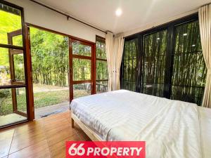 a bedroom with a bed and large windows at Nature Getaway in Classic Thai Home - Quiet Local Life in Chiang Mai