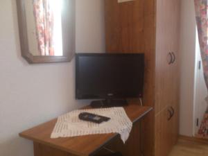 een bureau met een monitor en een afstandsbediening. bij Brig Apartments in Živogošće