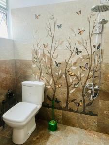 La salle de bains est pourvue de toilettes et d'oiseaux sur le mur. dans l'établissement VOGEL NEST, à Midigama-Est