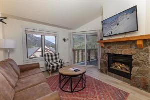 Una sala de estar con un sofá y una chimenea. en Full Renovated 1BR -Walk to Gondola & Kids Ski Free condo, en Dillon