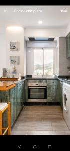 une cuisine avec des placards verts et une fenêtre dans l'établissement Apartamento Costa del Sol, à Almuñécar