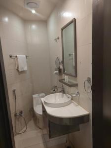 a bathroom with a sink and a toilet and a mirror at زيفل للشقق المخدومة in Buraydah +83 photos