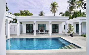 an exterior view of a house with a swimming pool at Tarn Villa Krabi in Krabi