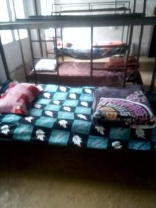 a bed with a blue and white comforter in a bedroom at Himalayan Mountain View, Triund Trekking Hostel in Dharamshala