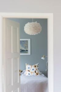 a bedroom with blue walls and a bed with pillows at Lägenhet med utsikt över jämtländska fjällvärlden in Frösö +10 photos
