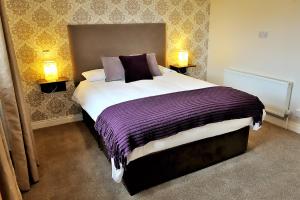 um quarto com uma cama grande e 2 candeeiros em Hatton's of Garadice em Garadice