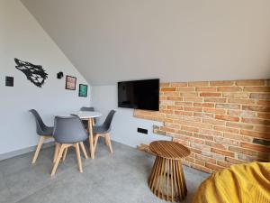 a room with a brick wall and a table and chairs at Wataha pod Basztami - Beta - Domki całoroczne in Wünschelburg