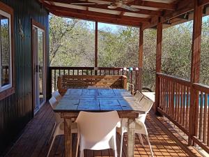 a wooden table and chairs on a deck at Sunset on Kingfisher in Marloth Park