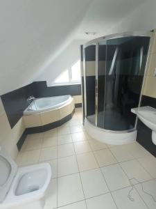 a bathroom with a tub and a toilet and a sink at 3izbový rodinný dom s krbom in Ružomberok