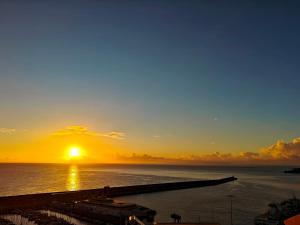 a sunset over the ocean with a pier at Vivienda Balcón al amanecer in Santa Cruz de la Palma