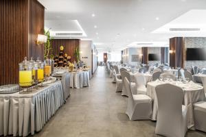 a banquet hall with white tables and white chairs at Elaf Qinwan Hotel in Mecca