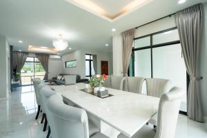 a dining room with a large white table and chairs at The One Pool Villa เขาใหญ่ in Ban Tha Maprang