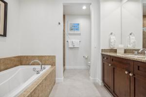 a bathroom with a tub and a sink and a toilet at T21 Lux Villa With Fountain View Condo in La Quinta +47 photos