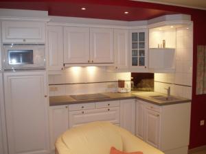 cocina blanca con armarios blancos y microondas en Domein Hengelhoef en Houthalen