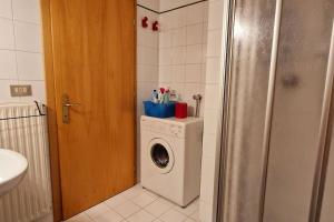 a bathroom with a washing machine and a washer at trilocale panorama val di fiemme in Predazzo +9 photos