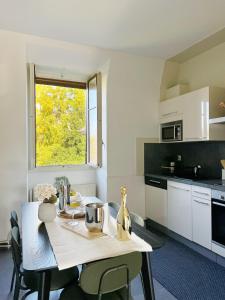 a white kitchen with a table and a window at Montreux Riviera Suite Waterfront 3 Bedrooms Private Parking in Montreux