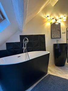 a bath tub with a faucet in a room at Le Loft in Mennecy