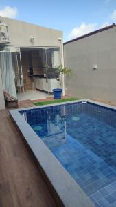 a large swimming pool with a blue tiled floor at Itapuã Beach II Espaço climatizado com piscina privativa e área gourmet! in Salvador +5 photos