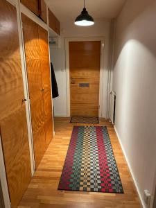a hallway with a door and a colorful rug on the floor at Apartment in Skellefteå