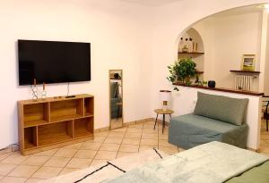 a living room with a flat screen tv and a chair at Rosy Suite Bed and Breakfast in Serravalle Scrivia