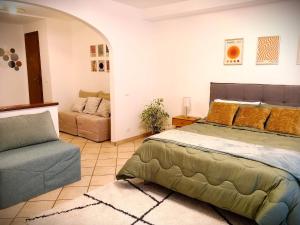 a bedroom with a bed and a couch at Rosy Suite Bed and Breakfast in Serravalle Scrivia