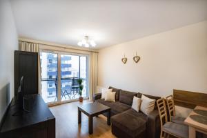 een woonkamer met een bank en een tv bij Cosmo Apartments in Gdańsk
