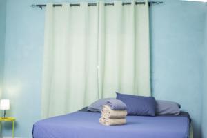 a bed with a pile of towels on it at Rio de Janeiro to Conakry KIPE in Conakry