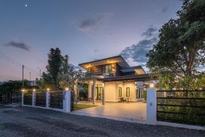 a house with a gate in front of it at The garden pool villa resort in Ban Muang Wa