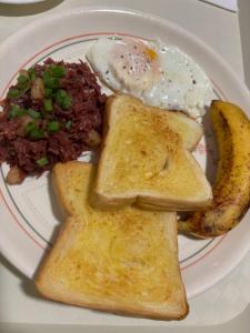 a plate of breakfast food with toast and eggs at Kataluma Inn in El Nido
