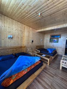 a bedroom with two beds and a wooden ceiling at Hotel 19 Tosh in Tosh