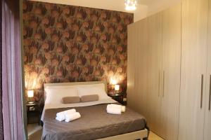 a bedroom with a bed with two towels on it at Casa Vacanze Happy Home in Zafferana Etnea