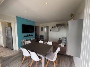 una sala da pranzo e un soggiorno con tavolo e sedie di Résidence Hermitage 6 pers avec parking a Le Touquet-Paris-Plage