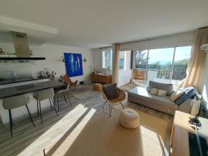 uma sala de estar com um sofá e uma mesa em Superbe appartement piscine, tennis, vue mer et décoré avec goût em Cassis