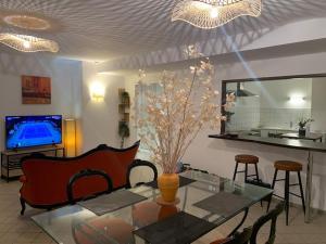 a living room with a glass table and a television at Le manoir étoilé Terrasse et Sauna in Neufchâteau