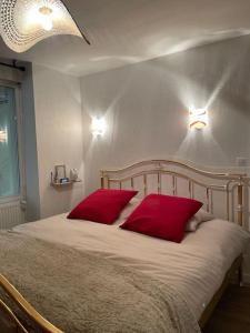 a bedroom with a bed with two red pillows at Le manoir étoilé in Neufchâteau