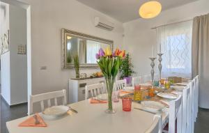- une salle à manger avec une table blanche et des fleurs dans l'établissement Pet Friendly Home In Naselje Muzini, à Tomišići