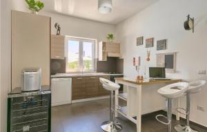 - une cuisine avec une table et deux tabourets dans l'établissement Pet Friendly Home In Naselje Muzini, à Tomišići