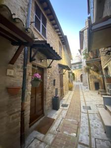 an alley in an old building with a door at La Dimora di Bianca Holiday House in Spello