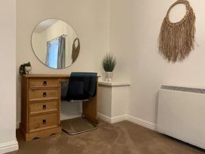 ein Spiegel über einem Schreibtisch mit einem Stuhl in einem Zimmer in der Unterkunft Braunton Breaks - North Beach Cottage in Braunton