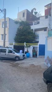 two cars parked in a parking lot next to a building at Yousef appartement in Taghazout