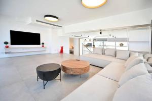 a living room with a couch and a table and a tv at Ben Yehuda Dream Penthouse in Tel Aviv