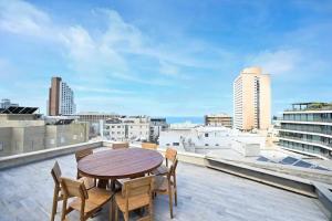 a table and chairs on the roof of a building at Ben Yehuda Dream Penthouse in Tel Aviv