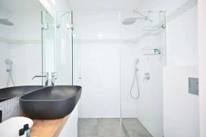 a bathroom with a black tub and a glass shower at Ben Yehuda Dream Penthouse in Tel Aviv +24 photos